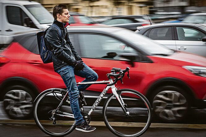 Radfahrer neben Autoverkehr auf Berlins Straßen