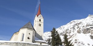 Eine Kirche vor schneebedeckten Bergen