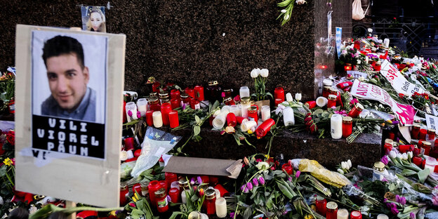 Viele rote Kerzen, Blumen und Fotos von Opfern des Anschlags