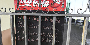 Schild vor einem Lokal erklärt dessen Schließung