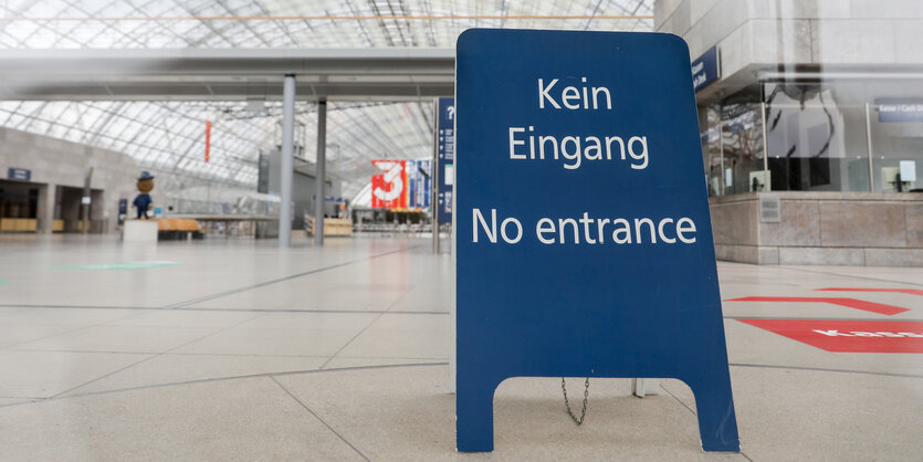 Blaues Schild mit weißer Schrift "Kein Eingang" steht in menschenleerer Halle