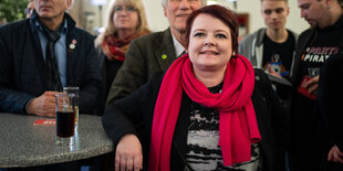 Verena Osgyan stützt sich mit dem Ellbogen auf einen Tisch und guckt nach vorne