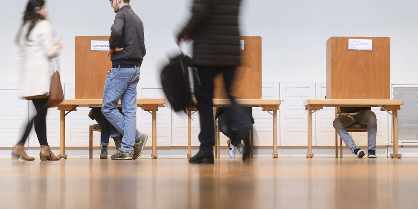 Menschen in einem Wahllokal in Bayern