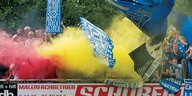 Fans des VfB Oldenburg schwenken Fahnen und zünden Pyrotechnik.