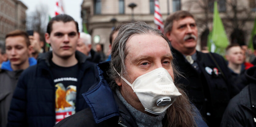 Demo, im Vordergrund Mann mit Mundschutz.