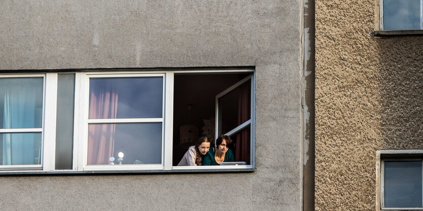 Zwei frauen schauen aus dem Fenster