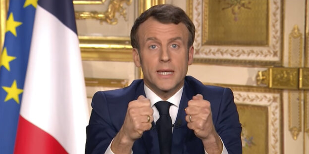 Vor einer französischen Fahne ballt der französische Präsident Macron die Fäuste bei seiner Fernsehansprache