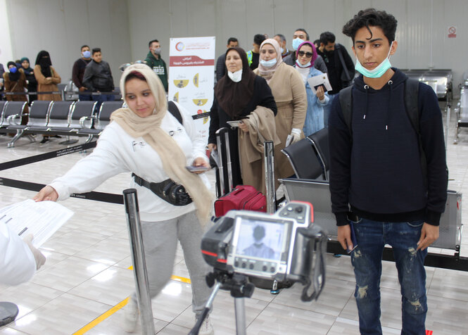 Passagiere stehen in einer Schlange bei der Ankunft am Flughafen in Misrata.