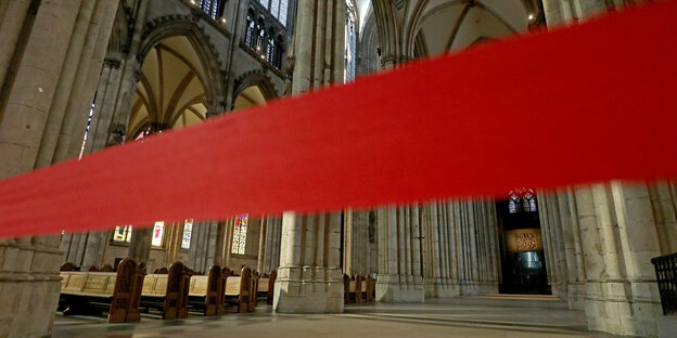 Ein rotes Absperrband ist vor den Eingang zu einer Kathedrale gespannt.