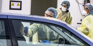 Test auf den Coronavirus durchs Autofenster in einer mobilden Teststation.