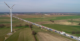 Luftaufnahme einer Landschaft und einer Straße, wo Autos und LKWs sich stauen