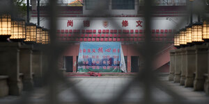 Ein menschenleeres Stadion in Wuhan, durch einen Zaun fotografiert.