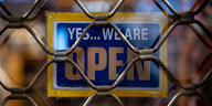 Ein geschlossenens Geschäft mit dem Schild: Yes, we are open.