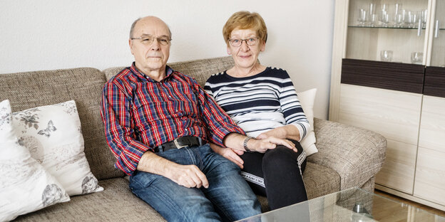 Ein Mann und eine Frau sitzen auf einem Sofa nebeneinander