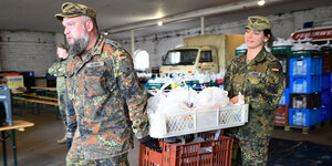 Soldaten tragen Essensvorräte in Kisten.