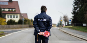 Ein Polizist kontrolliert die Ortsein- und ausfahrt von Mitterteich und hält eine Haltekelle in der Hand