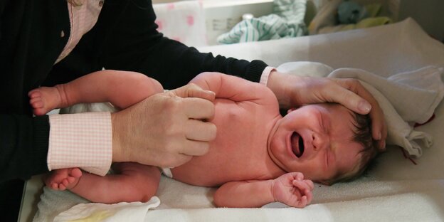 Ein Neugeborenes wird untersucht