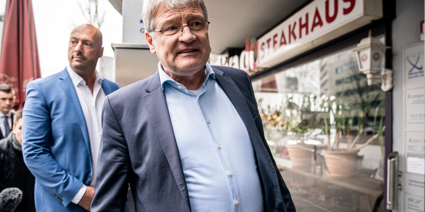 Ein Mann in Hemd und Jackett vor einem Steakhaus