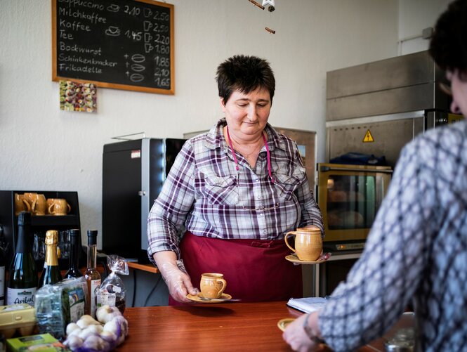 Eine Frau verkauft gerade einen Kaffee: In Jauernigs Backstube gibt es neben Brot und Kuchen auch Bioprodukte zu kaufen