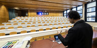 Ein Hochschullehrer hält eine Vorlesung vor einem leeren Saal.