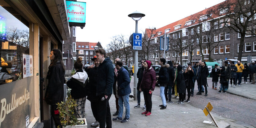 Menschen stehen in einer Schlange vor einem Coffeeshop.