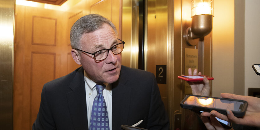 Richard Burr, ein Mann mit grauen Haaren und Brille, spricht mit Reportern