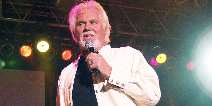 Kenny Rogers mit einem Mikrofon in der Hand