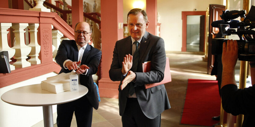 Bodo Ramelow und Mario Voigt desinfizieren sich die Hände.