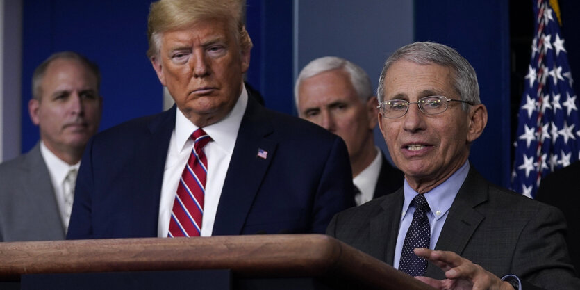 Trump hört zu, während Fauci spricht