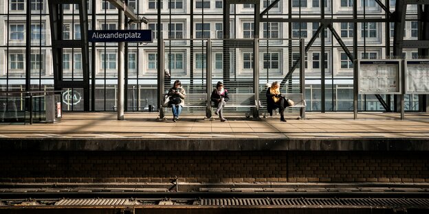 3 personen sitzen am Bahngleis Alexanderpatz