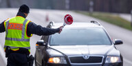 Ein Polizist winkt ein Auto an den Straßenrand