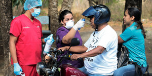 Temperaturmessung, Menschen mit Atemschutzmaske und Motorradfahrer