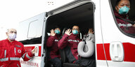 Medizinisches Personal aus China winkt bei der Ankunft in Italien.