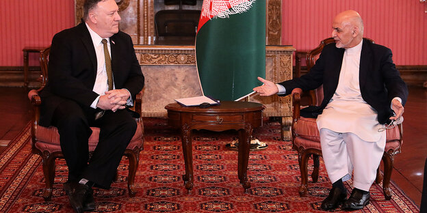 Pompeo und Ghani sitzen auf Stühlen, dazwischen ein Tisch und die afghanische Flagge