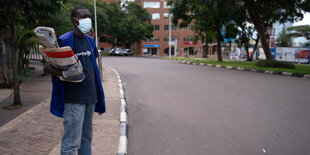 Zeitungsverkäufer an einer leeren Straße in Kigali.