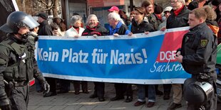 Eine Anti-Nazi-Demo wird von zwei Polizisten begleitet