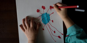 Ein Mädchen zeichnet das Coronavirus