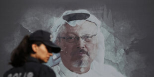 Eine Passantin geht vor einem Bild von Kashoggi vorbei