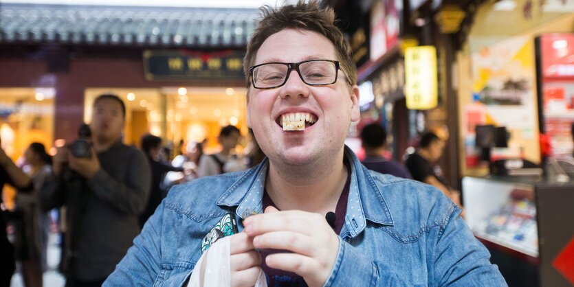 Ein junger Mann mit Essen im Mund