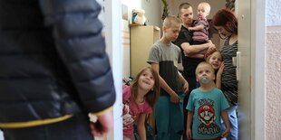 Familie bekommt eine Lebensmittellieferung. Kinder stehen in der Tür