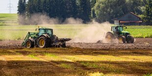 Stoppelfeld mit Guelle wird von zwei Traktoren umgeackert