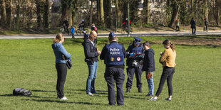 Menschen und Polizei auf einer Wiese im Park