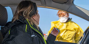 Eine Frau sitzt im Auto und wird gestestet