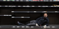 Soran Ahmed , der Inhaber eines Supermarktes in Schöneberg, hat sich in die leeren Regale für ein Foto gelegt