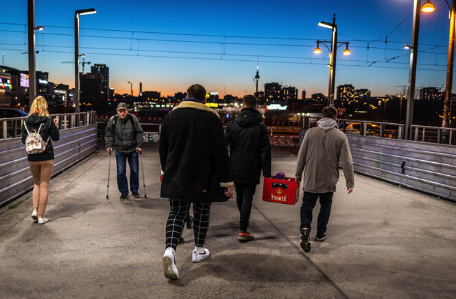 Auf einer Brücke am S-Bahnhof Berlin-Warschauer Brücke schleppen zwei junge Männer eine Kiste Bier