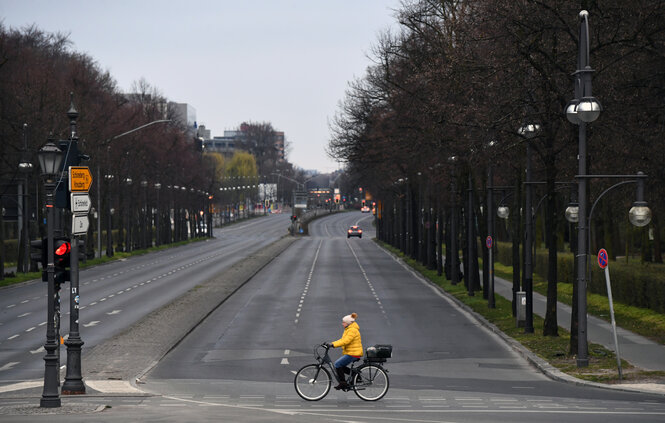 Leere Straße mit einer Radfahrerin