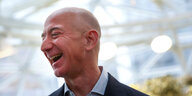 Jeff Bezos lacht bei einem Pressetermin.