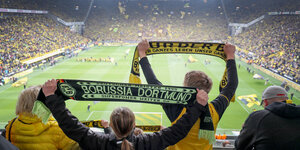 Volles Stadion und Fans mit Schal in Dortmund.