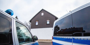 Zwei Polizeiautos vor einem Wohnhaus