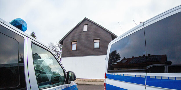 Zwei Polizeiautos vor einem Wohnhaus